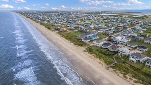 Luchtbeeld van een kustgebied met huizen aan het strand.