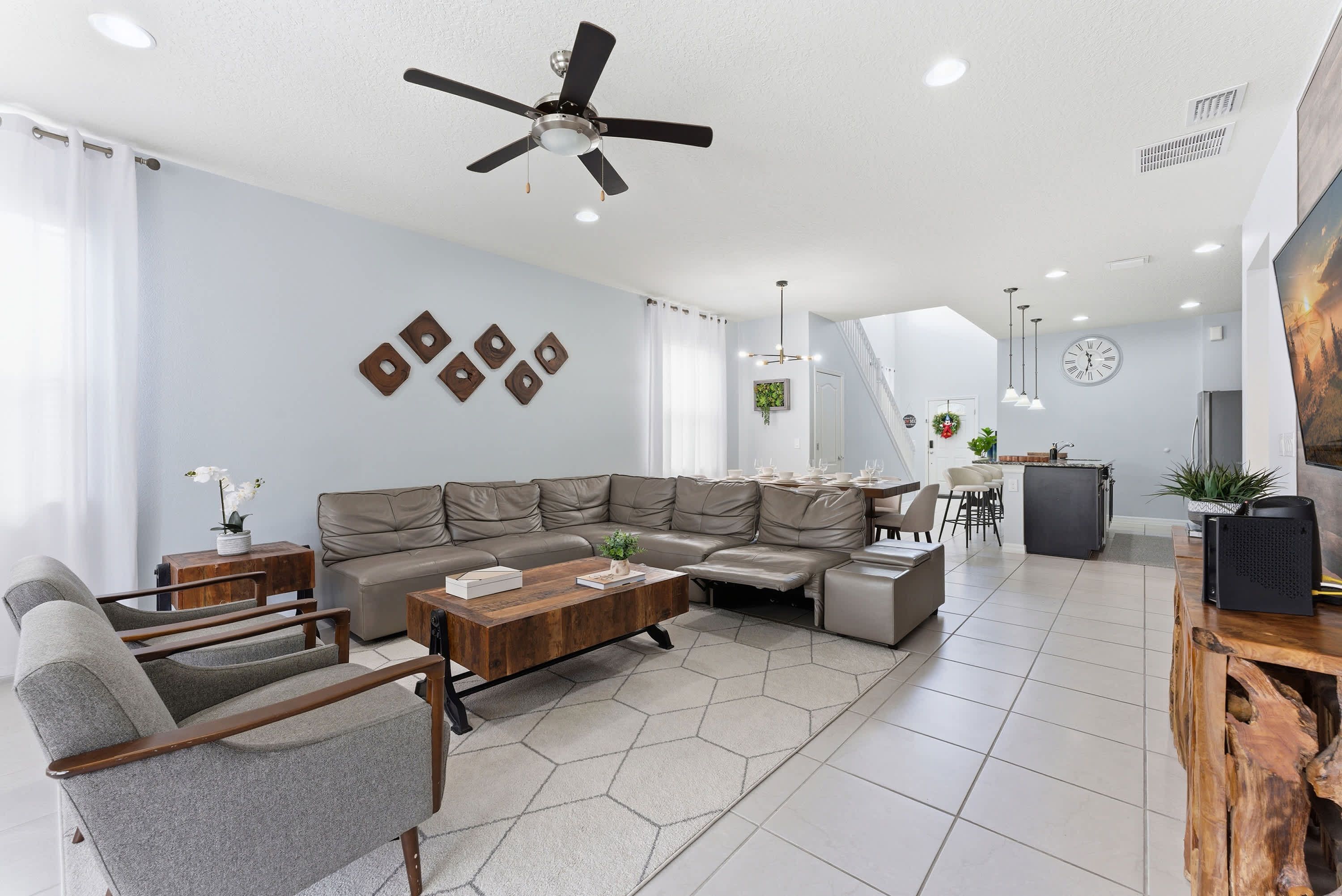 A modern living room with a sectional sofa, a coffee table, and a TV stand.