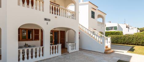 A two-story building with a balcony, a staircase, and a sign that reads 'BLOQUE'.