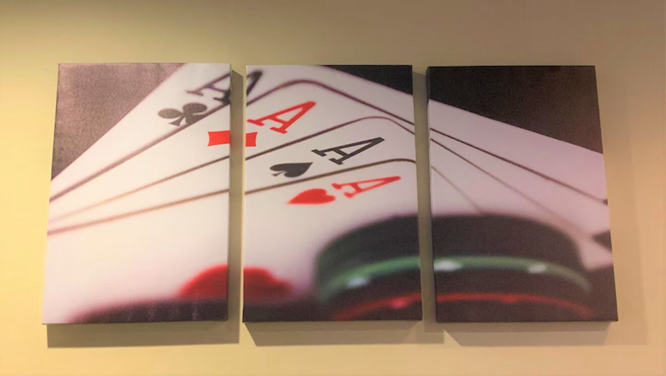 A wall with three playing cards: two aces and one king.