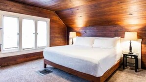 A bedroom with a wooden ceiling, a bed with white bedding, two bedside lamps, and a window with blinds. - Ultimate Getaway: Expansive Home with Hot Tub & Relaxation (Louisville)