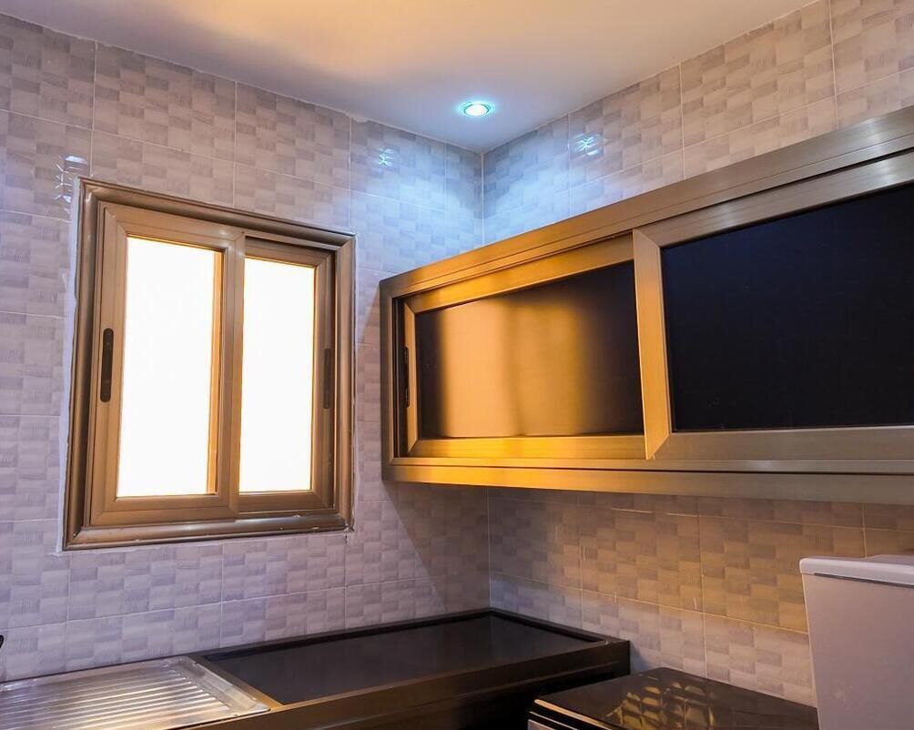 Una cucina con una finestra, un forno a microonde integrato e un piano di lavoro.