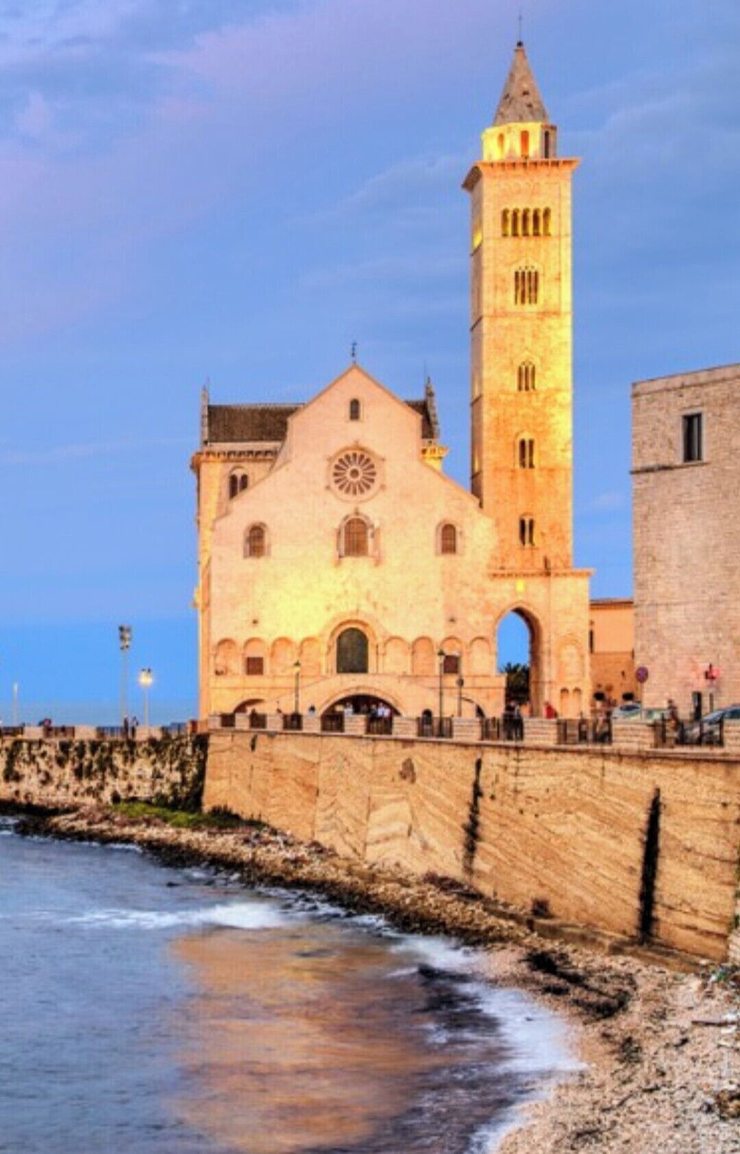 Una iglesia costera con una torre destacada y una amplia entrada de arco.