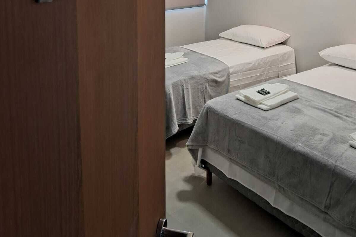 A hotel room with two beds, a wooden door, and a sign indicating room number 209.