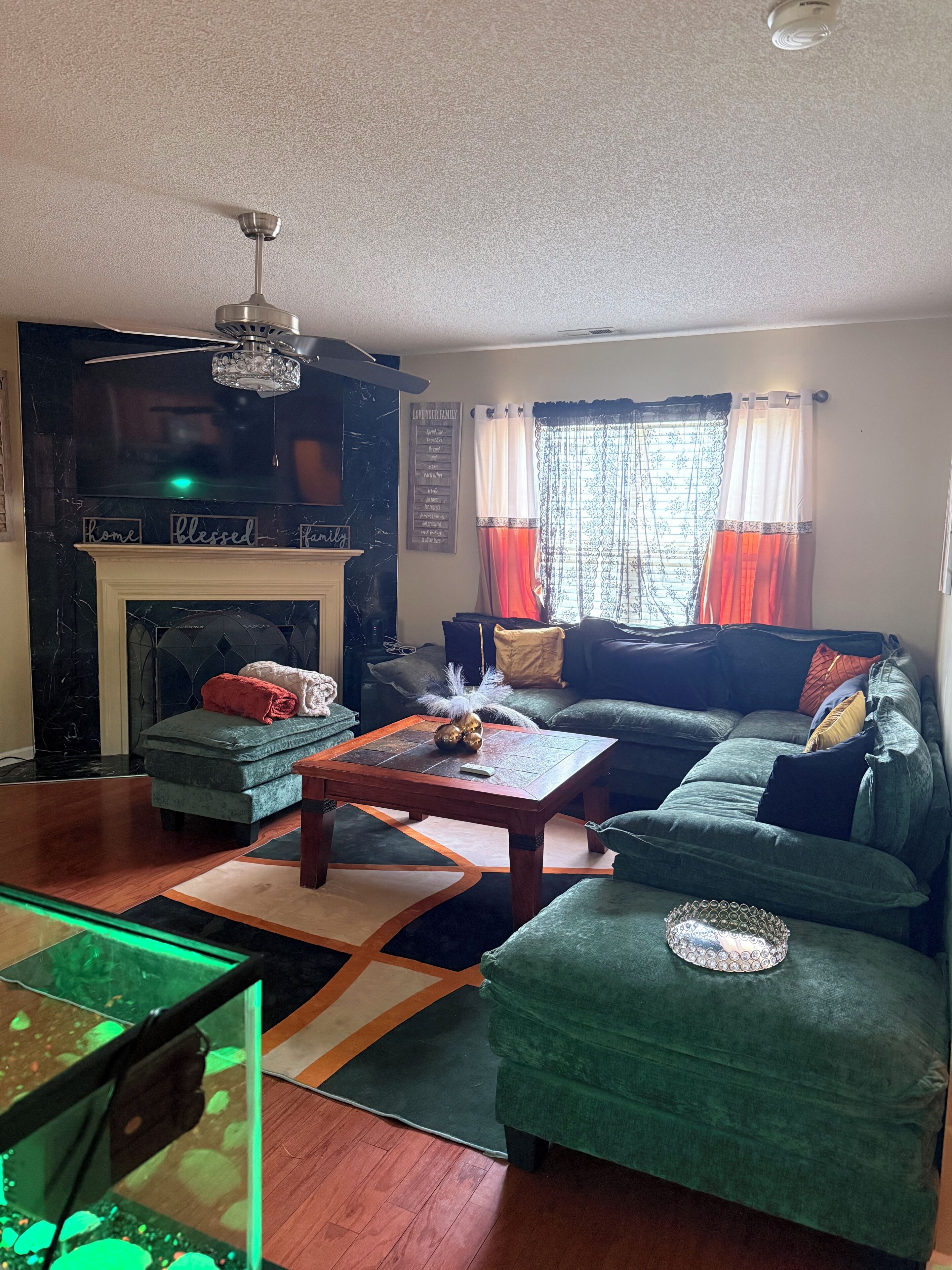 Una sala de estar con chimenea, un sofá, una mesa de centro y una televisión.