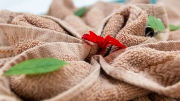 Un gros plan d’un tissu texturé orné d’une fleur rouge au centre.