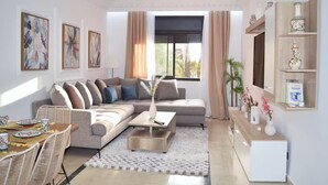 A modern living room with a sofa, coffee table, and dining area. - Menara Palms Marrakech (Marrakech)