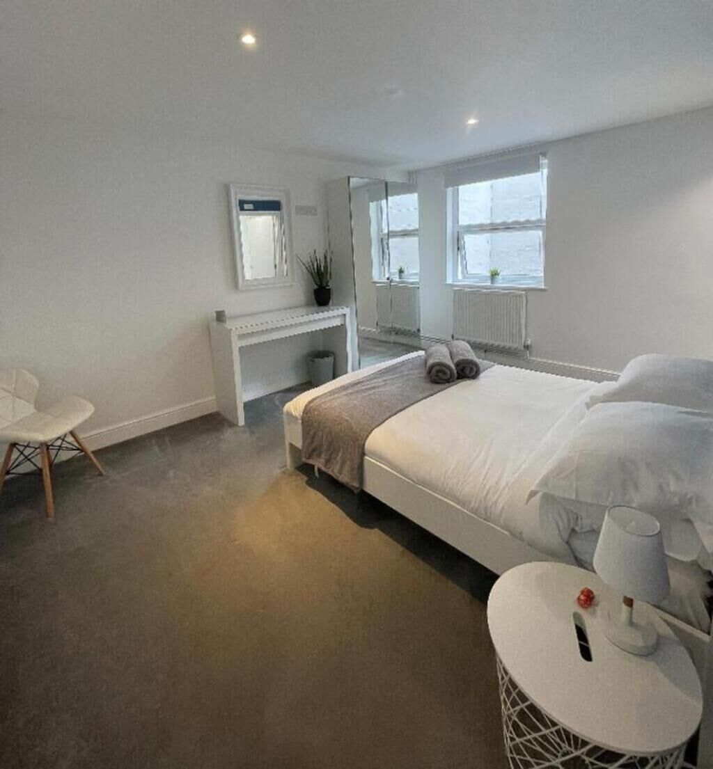 Un dormitorio moderno con una cama grande, un escritorio y una silla.
