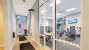 Ett träningscenter med träningsutrustning, glasdörrar och en reception.