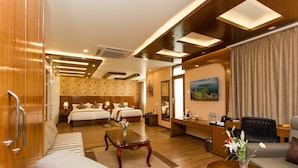 A hotel room with a large bed, a desk, a chair, and a TV. - Hotel Buddy (Kathmandu)