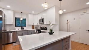 Una cocina moderna con armarios blancos, electrodomésticos de acero inoxidable y una isla grande.