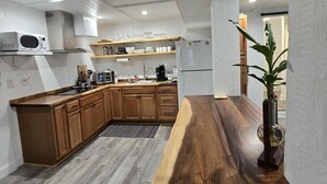 A modern kitchen with wooden cabinets, a central island, and a built-in microwave.