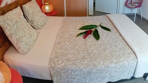 Une chambre à coucher avec un lit à baldaquin, une table de chevet avec une lampe et un fauteuil.
