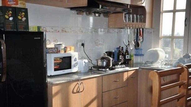 A kitchen with a microwave, stove, and various kitchen utensils. - Bliss Apartment (Kathmandu)