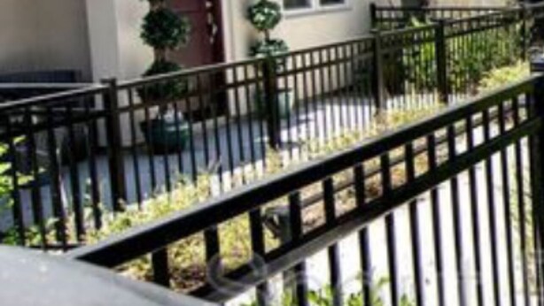 A two-story building with a beige facade, dark shutters, and a small porch area. - Charming 2-bedroom townhome in delightful Murrieta with AC (Murrieta)