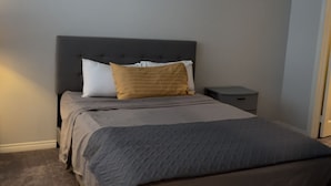 A bedroom with a bed, a nightstand, and a bedside table. - Charming 2-bedroom townhome in delightful Murrieta with AC (Murrieta)