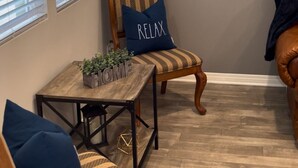 A cozy living room with a wooden coffee table, two patterned armchairs, and a blue pillow with "RELAX" on it. - Charming 2-bedroom townhome in delightful Murrieta with AC (Murrieta)