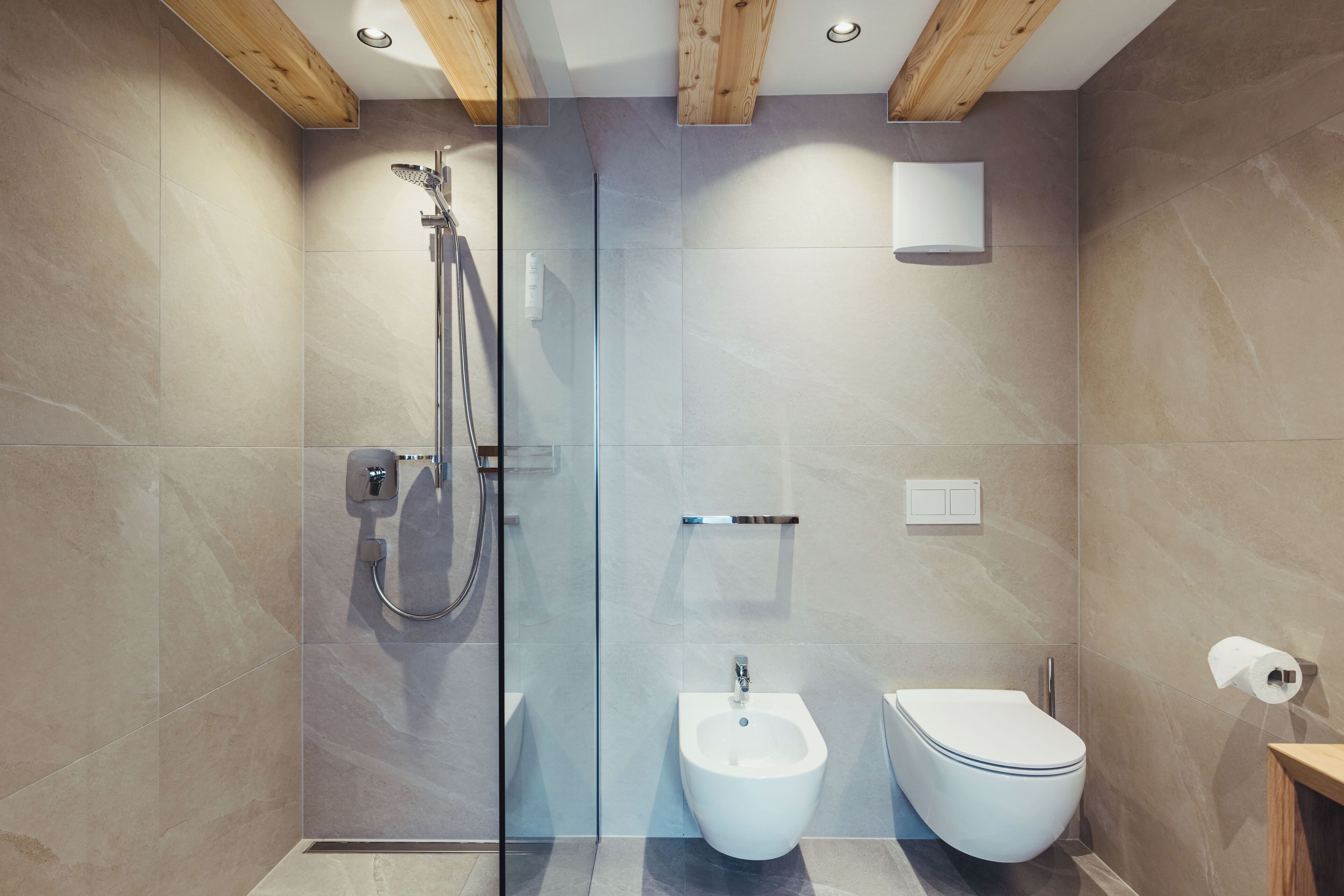 Une salle de bain moderne dotée d’une douche à parois de verre, d’un bidet et de toilettes.