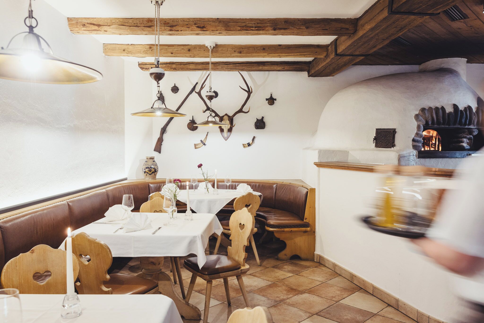 Un restaurante con mobiliario de madera, manteles blancos y una decoración rústica.