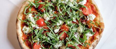 Een pizza met toppings op een wit bord.