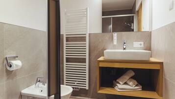 A modern bathroom with a toilet, sink, and towel rack.