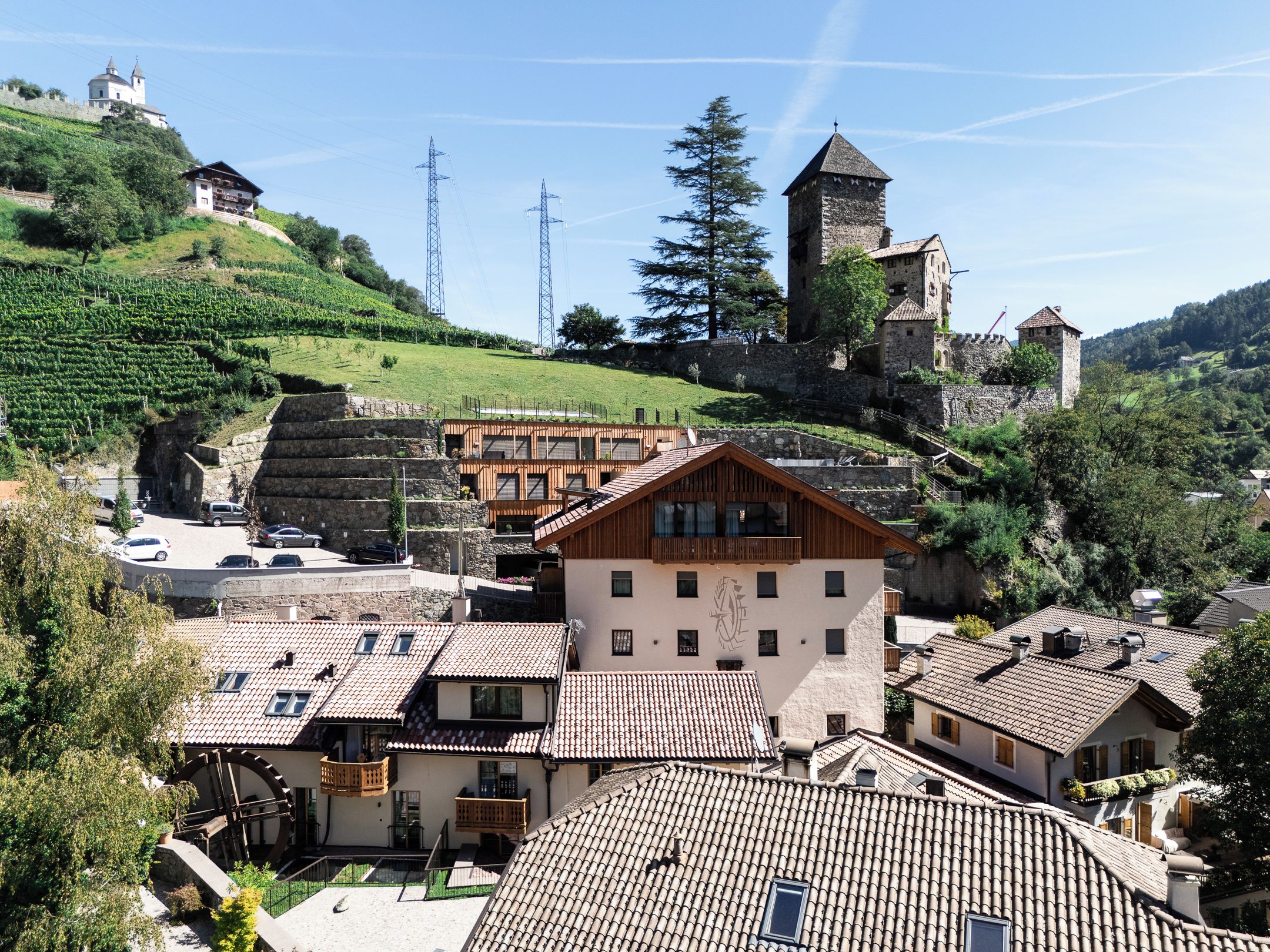 A hillside village with traditional architecture, including stone buildings and a castle-like structure.