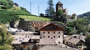 A hillside village with traditional architecture, including stone buildings and a castle-like structure.
