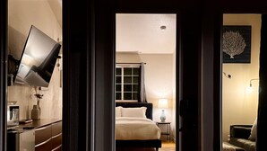 Une chambre d’hôtel équipée d’un lit, d’une table de chevet, d’une lampe et d’un téléviseur fixé au mur.