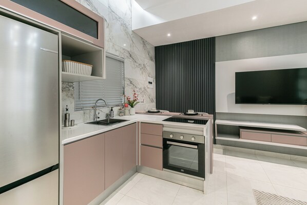 A modern kitchen with a built-in oven, a sink, and a microwave.