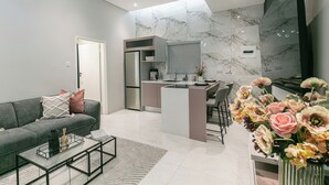 Ein modernes Wohnzimmer mit Sofa, Couchtisch und Essbereich mit Kücheninsel.