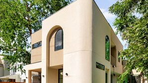 A modern two-story house with a curved facade, a front door, and a small front yard with a pool. - Eastside Lux Group  W Pool near Downtown (Austin)