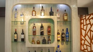 A bar area with multiple shelves displaying various liquor bottles and cans. - Hotel Marinha Pvt. Ltd (Kathmandu)