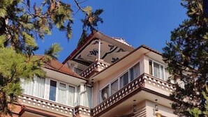 A multi-story building with a distinct architectural style, featuring ornate balconies and large windows. - Sherpa Homestay (Kathmandu)