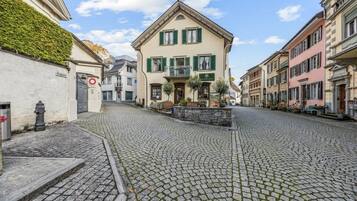 Eine Kopfsteinpflasterstraße mit historischen Gebäuden, einem Restaurantschild und einem Hydranten.