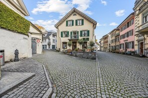 A cobblestone street with historic buildings, a sign for a restaurant, and a fire hydrant. - ReMo I Old town idyll on Lake Walen #1 | Mountain (Weesen)