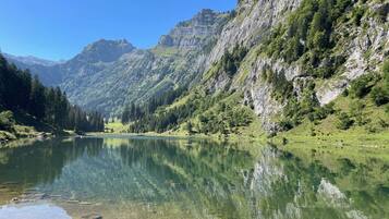 A mountain lake with clear water reflecting the surrounding landscape.