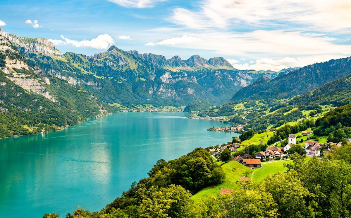 A mountainous landscape with a lake and a village.