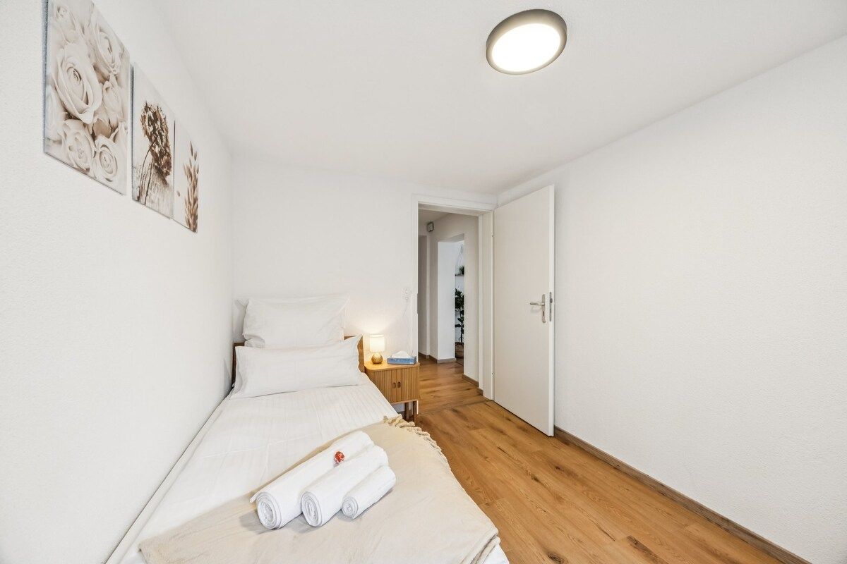 Ein Hotelzimmer mit einem Bett, einem Nachttisch und einem Wandbild.