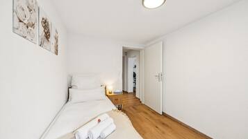 Ein Hotelzimmer mit einem Bett, einem Nachttisch und einem Wandbild.