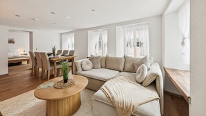 A modern living room with a sofa, coffee table, and dining area. - ReMo l Old town idyll on Lake Walen #1 - Balcony I near station + highway I parking lot (Weesen)