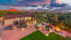 A two-story house with a deck, surrounded by a landscaped garden and a view of mountains. - Scenic West Sedona Escape with Thunder Mtn Views (Sedona)