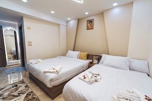 Una habitación de hotel con dos camas, un baño y un pasillo.