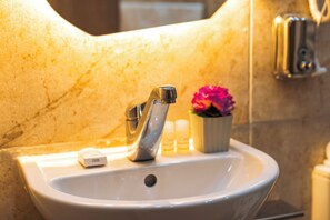 A bathroom sink with a faucet, a flower in a cup, and a soap dispenser. - Oriental Pyramids & GEM View (Giza)