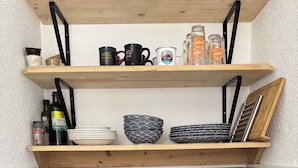 A kitchen with wooden shelves, a sink, and various kitchen items. - Superb Cosy and Warm Studio Near Belle étoile chairlift (Les Deux Alpes)