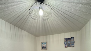 A small bedroom with a bed, a ceiling light fixture, a wall-mounted picture, and a small rug. - Superb Cosy and Warm Studio Near Belle étoile chairlift (Les Deux Alpes)