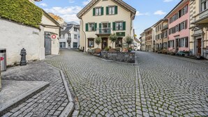 A cobblestone street with historic buildings, a sign for 'Krugasse', and a 'SACHSEN' sign indicating a hotel.