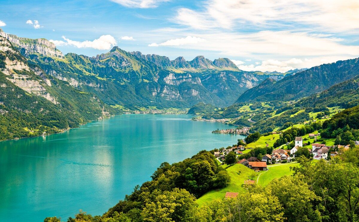 A mountainous landscape with a lake and a village.