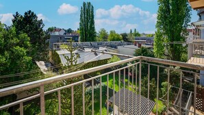 A residential area with multiple buildings, a clear sky, and a balcony with a view of the neighborhood. - Arcadio Home - Junior Suite (Graz)