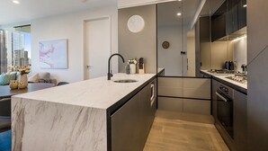 Una cocina moderna con encimera de mármol, electrodomésticos de acero inoxidable y vistas a la ciudad.
