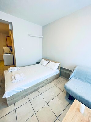 A single-bed room with a wooden headboard, white linens, and a small bedside table. - #704: Extra Spacious Studio (28m²), Metro, Heart of Thessaloniki "Frangomahala". (Thessaloniki)